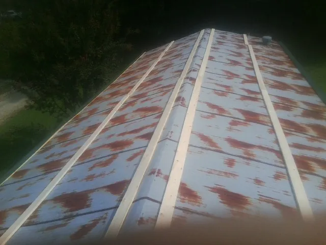 Rusted metal roof panels with new wood purlins before replacement — Storm Damage Roof Repair in Dandridge by Roofing Brothers