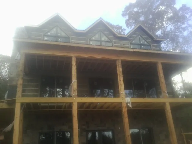 Dormers and porch framing on a large log home under construction — Roof Coating work by our crew in Dandridge