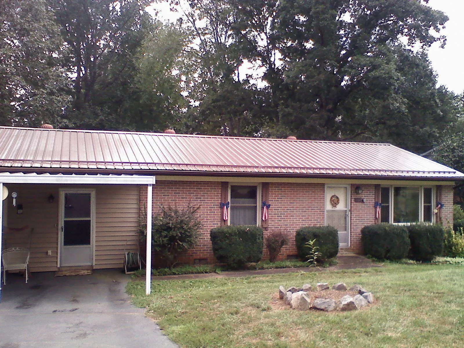 Bronze metal roof and carport on a brick ranch home — Roof Repair work by our crew in Dandridge